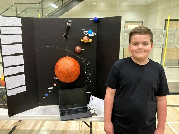 Student with his solar system project