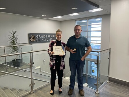 Two people holding up a certificate